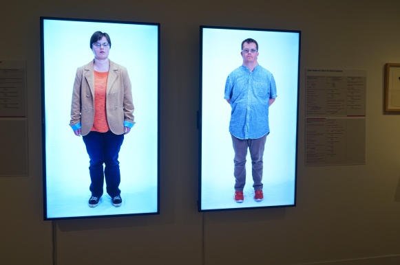Zwei Bildschirme zeigen einen Mann und eine Frau mit Down-Syndrom
